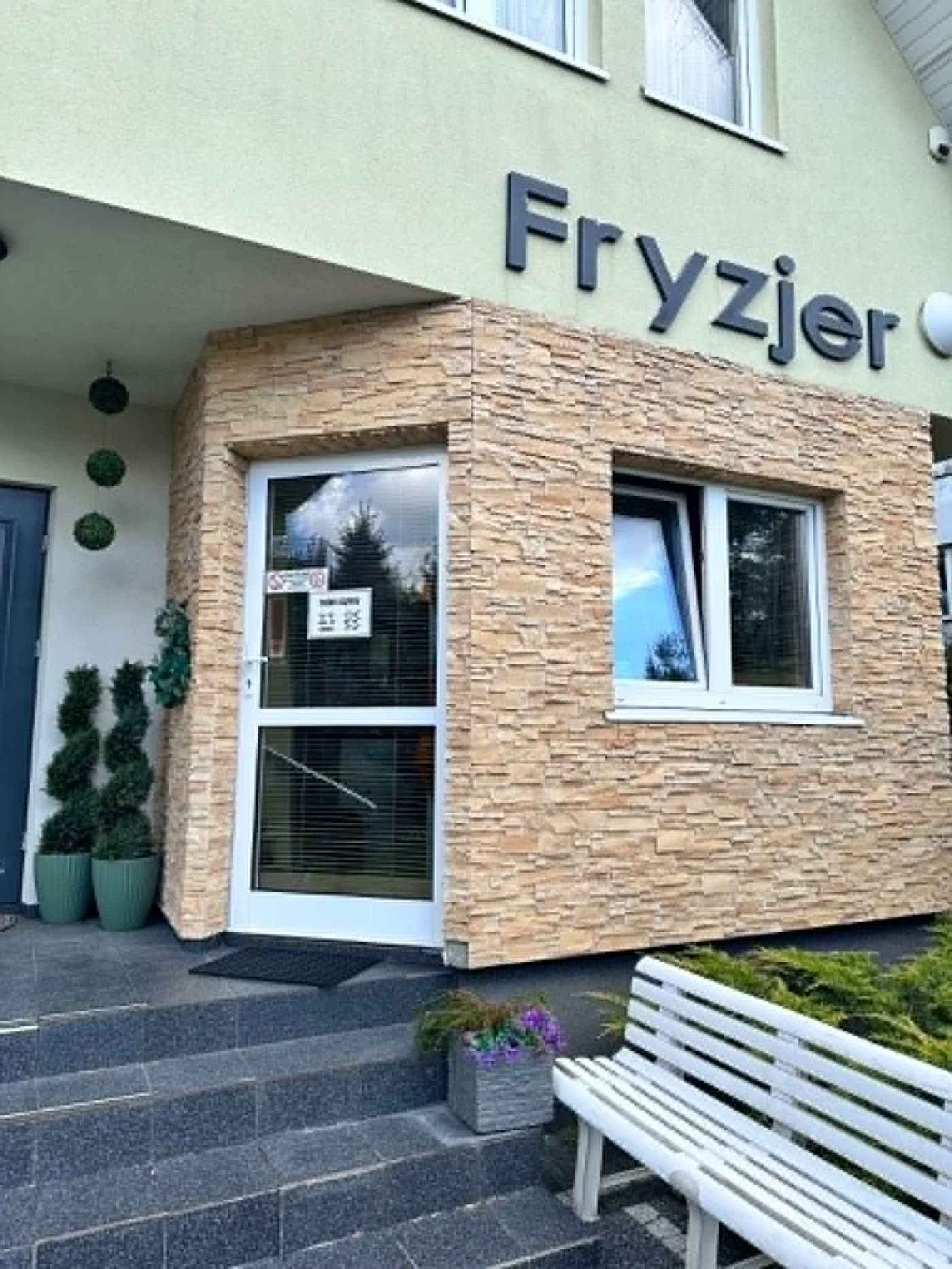 Wejście do salonu fryzjerskiego z napisem Fryzjer
